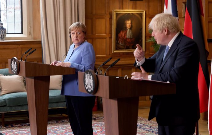 02 July 2021, United Kingdom, Buckinghamshire: UK Prime Minister Boris Johnson (R) and German Chancellor Angela Merkel, hold a joint press conference after their meeting at Chequers, the country house of the Prime Minister of the United Kingdom, in Buck