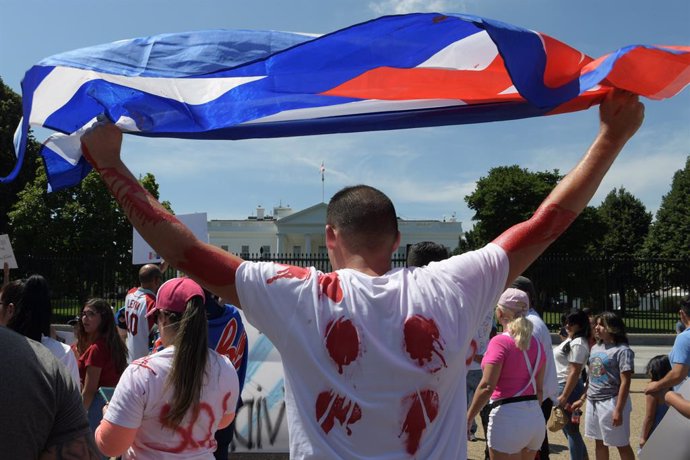 13 July 2021, US, Washington: Cuban demonstrators from We are more and We are not afraid's movement holds a Cuban flag during a rally in front of the White House to show their support for the people in Cuba that have taken to the streets to protest pand