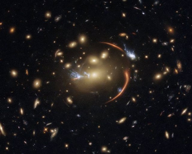 La distante galaxia MRG-M0138 w, captada por el Hubble con una lente gravitacional