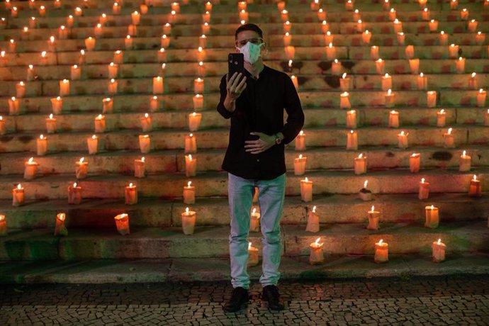 Archivo - 21 June 2021, Brazil, Rio De Janeiro: A man takes a selfie with the 500 candles that people lit in memory of the 500,000 people who have died so far in Brazil from the coronavirus (Covid-19). Photo: Fernando Souza/dpa