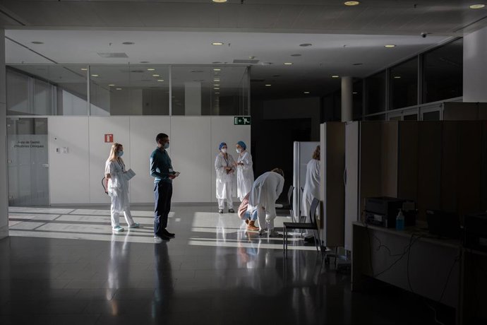 Archivo - Varias enfermeras vacuna a un profesional sanitario con la vacuna de Pfizer-BioNtech contra el COVID-19 en el Hospital de la Santa Creu i Sant Pau de Barcelona.