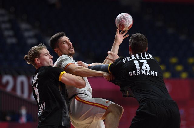 Juri Knorr y Hendrik Pekeler tratan de frenar a Alex Dujshebaev en el Alemania-España de los Juegos Olímpicos de Tokio. Photo: Swen Pförtner/dpa