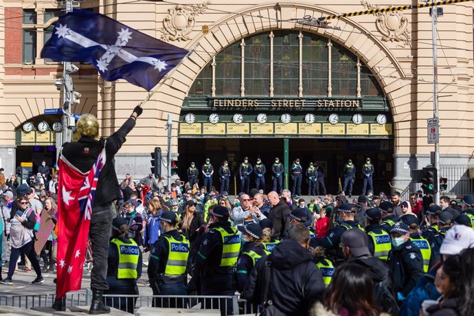 24 July 2021, Australia, Melbourne: Protesters march at a Freedom Day Rally in front of Flinders Street station in Melbourne blocking traffic and trams. Melbourne is currently in its fifth lockdown due to an outbreak caused but the Delta variant of the 