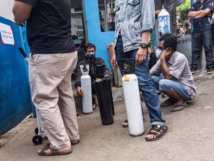 07 July 2021, Indonesia, Jakarta: Relatives of covid-19 patients wait outside an oxygen-filling center to refill their empty cylinders, as demand for the gas rises due to the spike in coronavirus infections. Photo: Agung Fatma Putra/SOPA Images via ZUMA