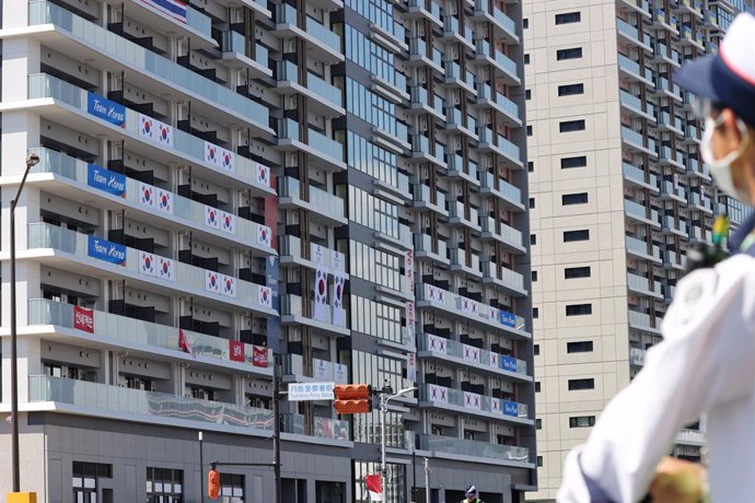 17 July 2021, Japan, Tokyo: An official removes banners with the words "I still have support from 50 million Korean people" from balconies at the athletes' village of the 2020 Tokyo Olympic Games. Photo: -/YNA/dpa