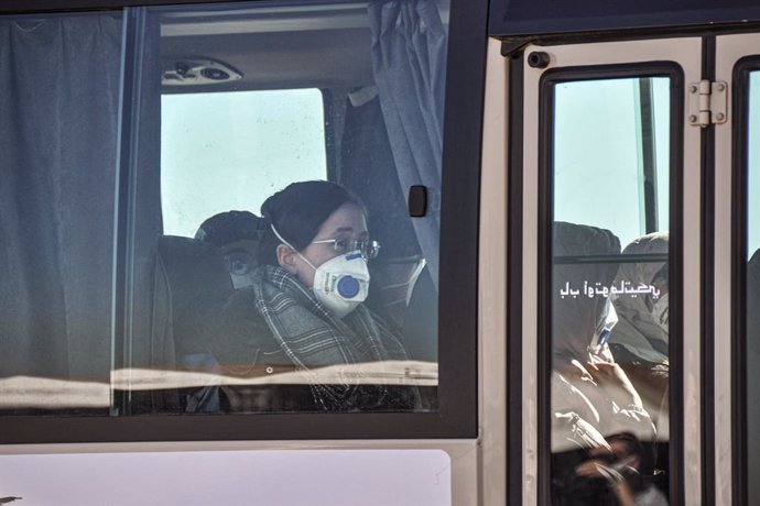 Archivo - 03 February 2020, Algeria, Algiers: Passengers, from Algeria, Libya and Mauritania, wearing surgical masks, leave on a transport bus at the the Houari Boumediene Airport, after arriving on an Algerian air plane following their evacuation from 
