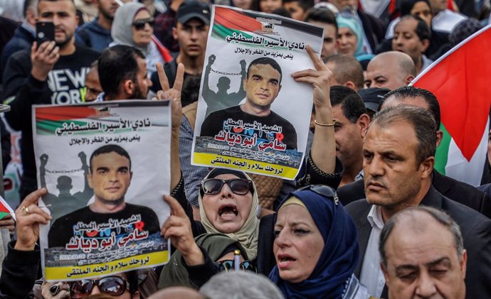 Archivo - 26 November 2019, Palestinian Territories, Nablus: Palestinian protesters hold placards with the picture of Sami Abu Diak, a Palestinian prisoner who died of cancer in Israeli jail, during a demonstration against the Trump administration's pol