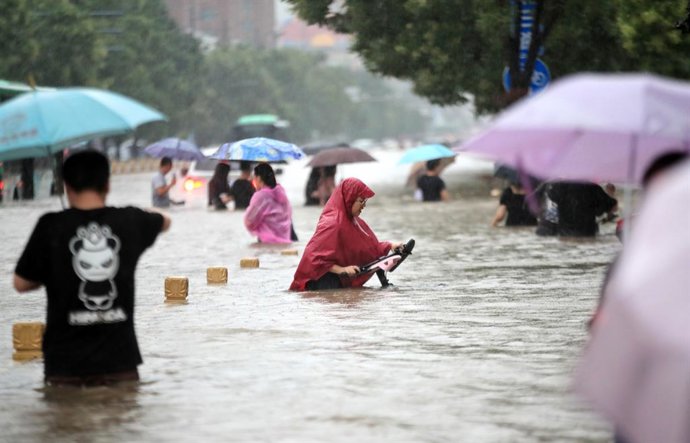 Gent camina per la carretera inundada després de pluges rcord a la ciutat de Zhengzhou, a la província central xinesa d'Henan.