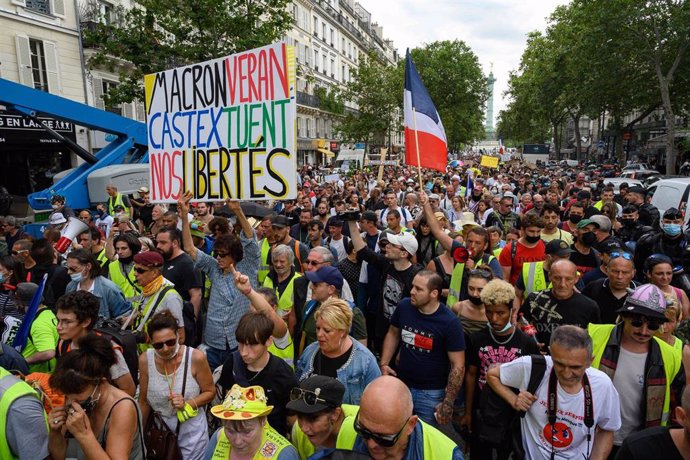 24 July 2021, France, Paris: People holds placards and flags during a demonstration at the Place de la Bastille with the Yellow Vests against the health pass imposed by the government. Photo: Julien Mattia/Le Pictorium Agency via ZUMA/dpa