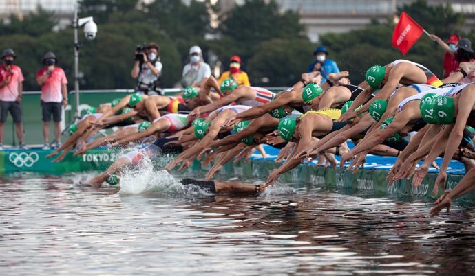 26 July 2021, Japan, Tokyo: Competitors jump into the water at the start of the swimming part of the Men's Triathlon Olympic distance (1.5 km swim, 40 km bike, 10 km run) during the Tokyo 2020 Olympic Games. Photo: Sebastian Gollnow/dpa