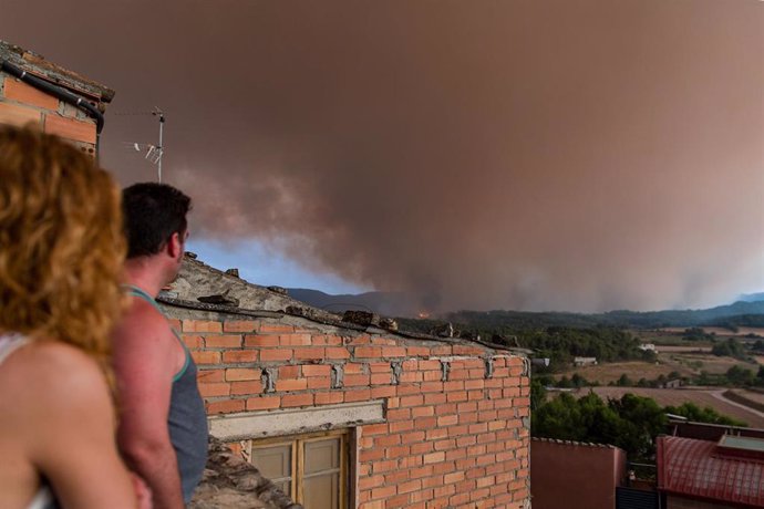 Vecinos con humo del incendio al fondo, a 25 de julio de 2021, en Sant Martí de Tous, Barcelona, Catalunya (España). 