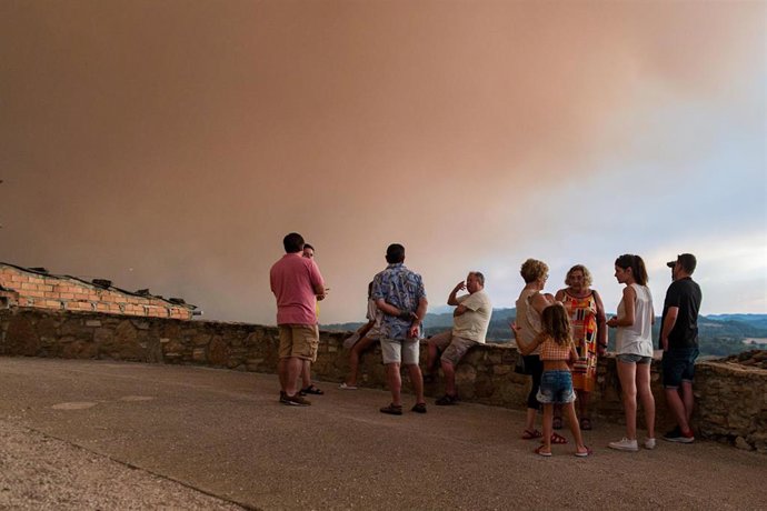 Vecinos con humo del incendio al fondo, a 25 de julio de 2021, en Sant Martí de Tous, Barcelona, Catalunya (España).