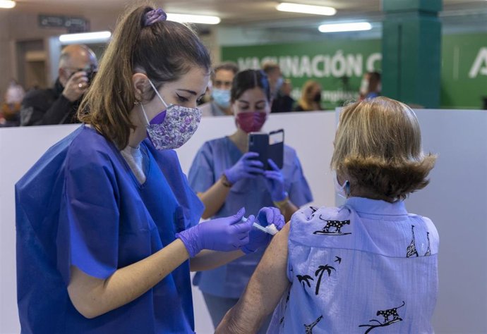 Archivo - Una sanitaria vacuna a una mujer