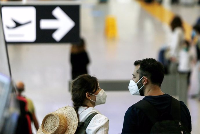 Archivo - 18 July 2020, Italy, Rome: Two passengers wear face masks as they walk at Leonardo da Vinci International Airport. Photo: Cecilia Fabiano/LaPresse via ZUMA Press/dpa
