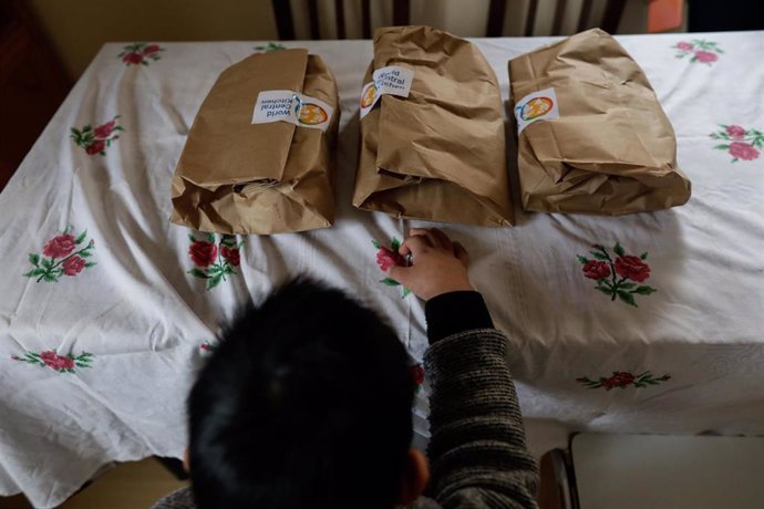 Archivo - Un niño durante la comida en su casa momentos antes de abrir el menú de la ONG del chef José Andrés, que reparte a las familias más necesitadas durante el estado de alarma provocado por el coronavirus (archivo). 