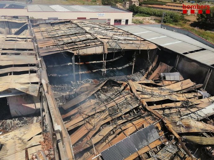 Cae el tejado de dos naves afectadas por el incendio en Montblanc (Tarragona), el 27 de julio de 2021.