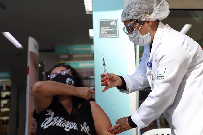 25 July 2021, Brazil, Sao Paulo: A woman receives a coronavirus vaccine in a tent set up on Paulista Avenue. According to data from Bloomberg News Agency and Johns Hopkins University, today, Sunday, a total of 131.6 million doses of an anti-Coronavirus 