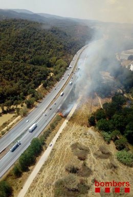 Incendi de vegetació al marge de l'autopista AP-7 a l'altura de Sant Celoni (Barcelona)