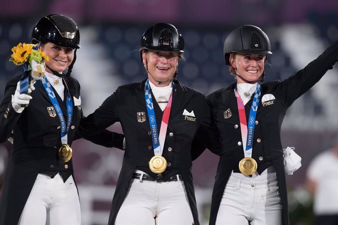 Germanys Dorothee Schneider, Isabell Werth and Jessica von Bredow-Werndl celebrating Dressage team gold at the Tokyo 2020 Olympic Games in Baji Koen Equestrian Park today. (FEI/Shannon Brinkman)