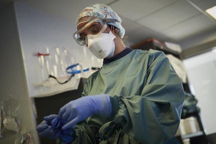 Archivo - Una trabajadora sanitaria se limpia las manos tras salir de una habitación de la UCI de la Clínica Universidad de Navarra, en Pamplona, Navarra, (España), a 10 de noviembre de 2020