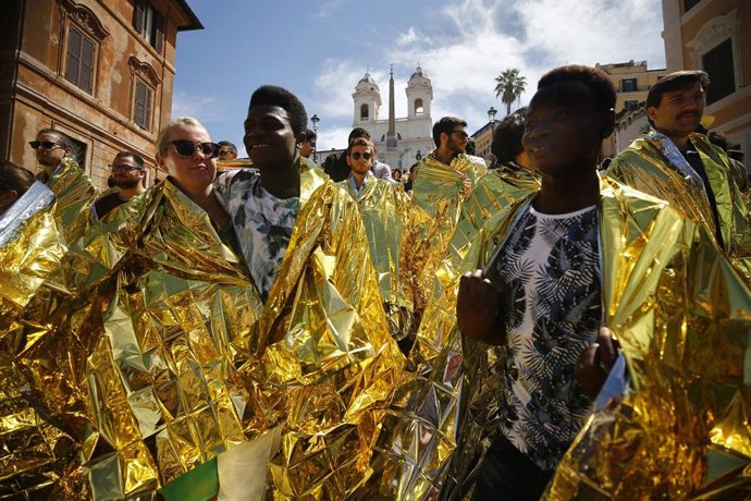Archivo - Personas urdidas con mantas doradas se reúnen en la Plaza de España de Roma mientras participan en una protesta organizada por miembros de la campaña #ioaccolgo (yo acojo) para expresar su solidaridad con los migrantes y refugiados