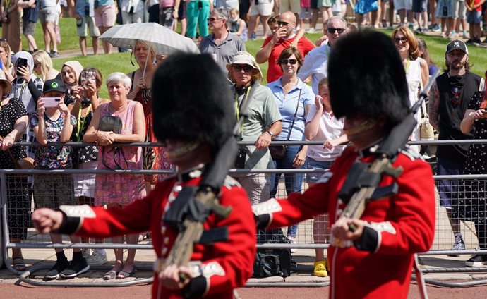 22 July 2021, United Kingdom, Windsor: People watch as members of the 1st Battalion Grenadier Guards take part in the Changing of the Guard at Windsor Castle in Berkshire, which is taking place for the first time since the start of the coronavirus pande