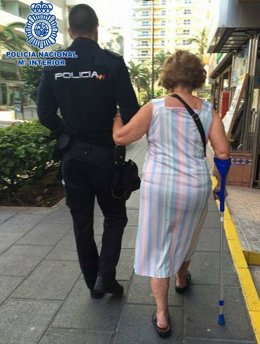 Un agente de la Policía Nacional con una víctima del robo