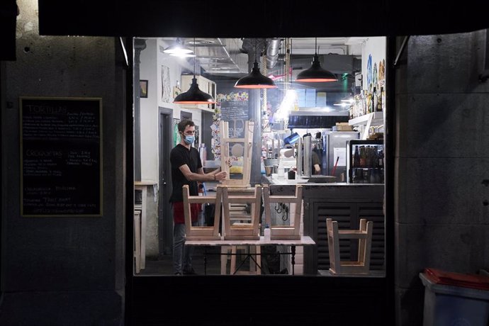 Archivo - Un trabajador recoge el interior de una cafetería de Madrid, a 31 de mayo de 2021, en Madrid (España). 