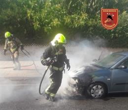 Los bomberos extinguen el incendio de un vehículo que se prendió fuego cuando circulaba