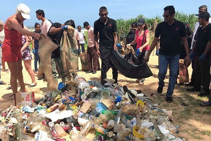 Archivo - Voluntarios de la compañía hotelera limpian una playa.