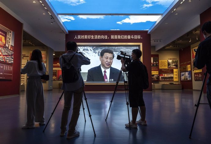 Archivo - Periodistas y otros filman junto a una pantalla grande que muestra al presidente de China, Xi Jinping, en el recién construido Museo del Partido Comunista.