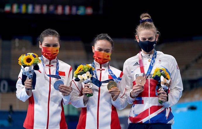 30 July 2021, Japan, Tokyo: (L-R) Silver medalist Lingling Liu of Team China, gold medalist Xueying Zhu of Team China and bronze medalist Bryony Page of Team Great Britain pose on the podium at the Women's Trampoline Final at Ariake Gymnastics Centre as