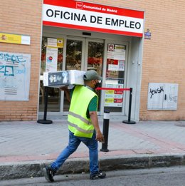 Archivo - Un repartidor pasa por una oficina del SEPE