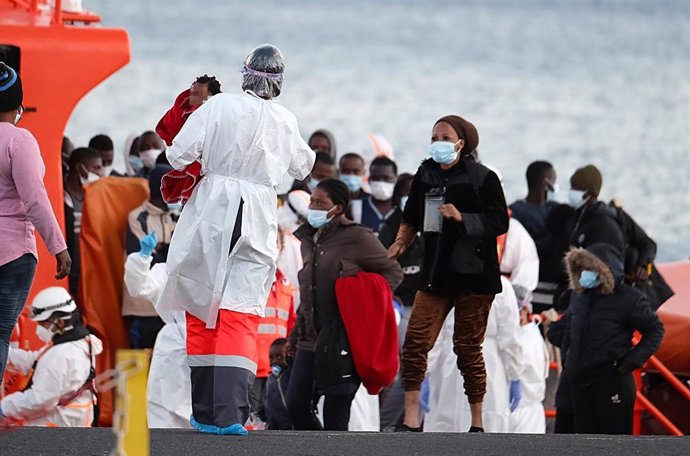 Archivo - Una sanitaria atiende a un grupo de migrantes tras el rescate del buque Salvamar Mizar a una patera en Fuerteventura.