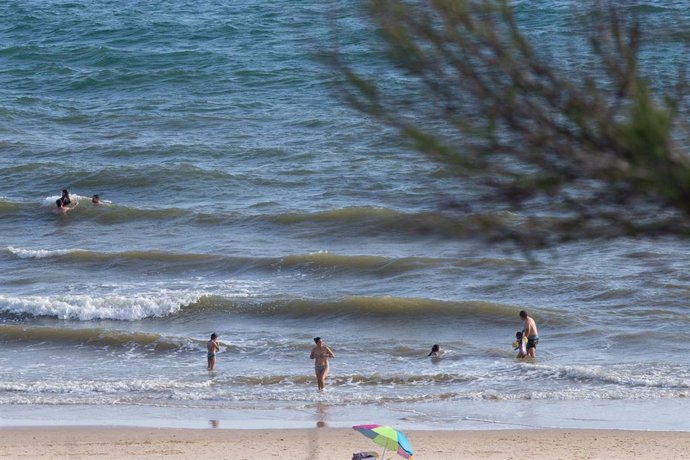Archivo - Personas bañándose en la playa en foto de archivo.