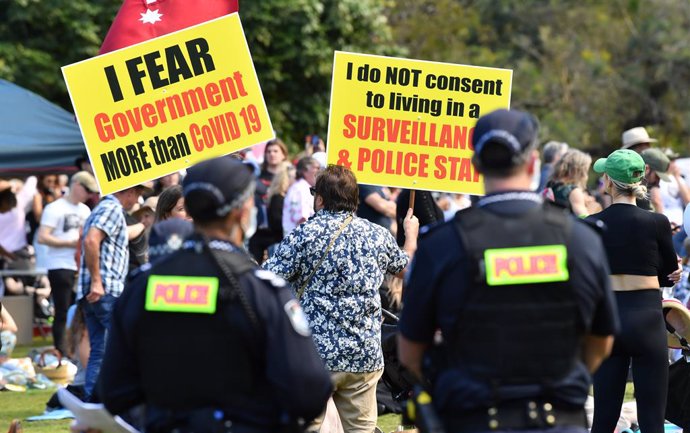 A Protestor is seen as Queensland Police look on during the World Wide Rally For Freedom anti-lockdown rally in Brisbane, Saturday, July 24, 2021. (AAP Image/Darren England) NO ARCHIVING