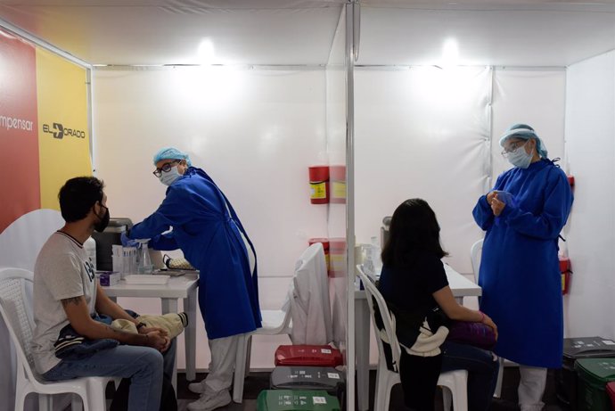 16 July 2021, Colombia, Bogota: Public health workers work at the first Corona vaccination centre established in a Colombian airport. Photo: Mariano Vimos/colprensa/dpa