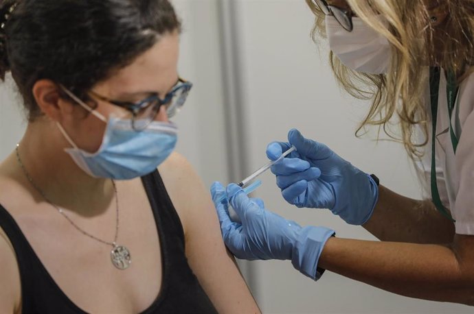 Una enfermera administra la vacuna contra el Covid-19 a una joven en el dispositivo puesto en marcha en la Ciutat de les Arts i les Cincies de Valencia, a 28 de julio de 2021