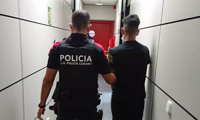 Agente de la Policía Canaria junto al detenido