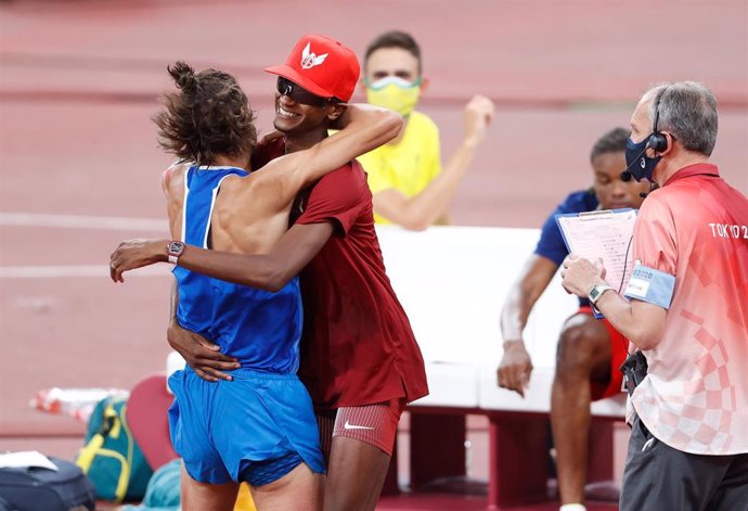 Qatar's Mutaz Essa Barshim (C) celebrates with Italy's Gianmarco Tamberi (L)after winning share Olympic high jump gold after finishing the Men's High Jump final of the athletics competition at the Olympic Stadium during the Tokyo 2020 Olympic Games.