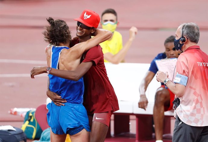 Qatar's Mutaz Essa Barshim (C) celebrates with Italy's Gianmarco Tamberi (L)after winning share Olympic high jump gold after finishing the Men's High Jump final of the athletics competition at the Olympic Stadium during the Tquio 2020 Olympic Games.