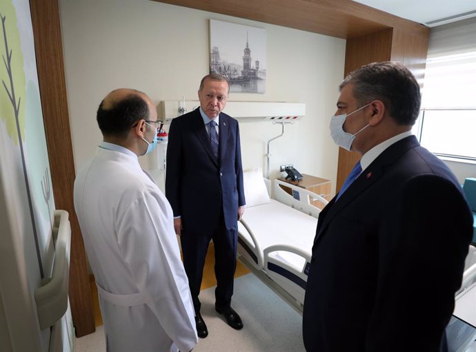 Archivo - 21 May 2020, Turkey, Istanbul: Turkish President Recep Tayyip Erdogan (C) and Turkish Health Minister Fahrettin Koca (R) talk to a health worker during a tour at the Basaksehir Cam and Sakura City Hospital ahead of its inauguration ceremony in