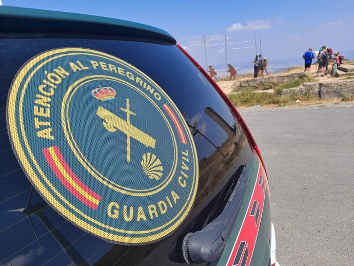 Vehículo de la Guardia Civil junto a un grupo de peregrinos