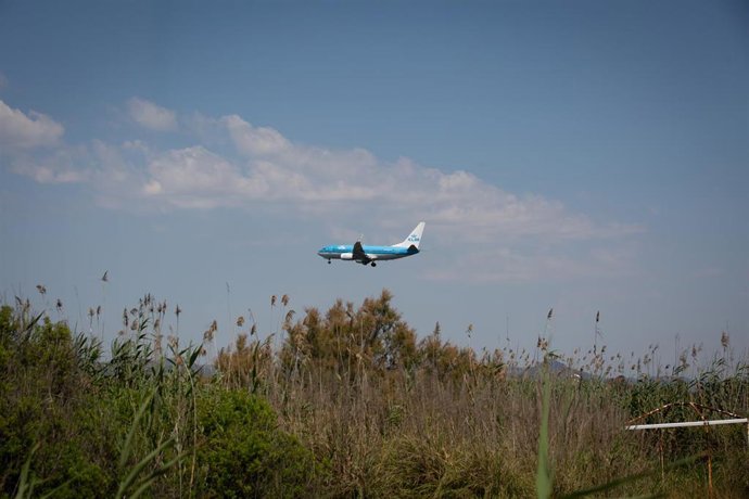 Archivo - Un avión vuela cerca del espacio protegido natural de La Ricarda, en el Prat de Llobregat