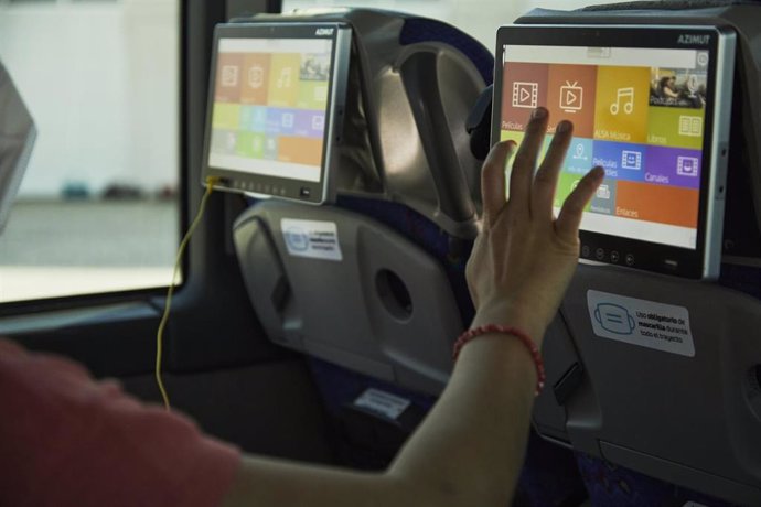 Archivo - Una usuaria de un autobús de Alsa con uno de los dispositivos multimedia a bordo