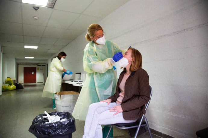 Archivo - Una sanitaria realiza a una mujer una prueba de detección del coronavirus.