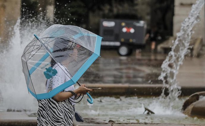 Una persona sostiene un paraguas mientras llueve