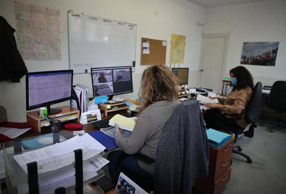 Archivo - Dos operarias protegidas con mascarillas trabajan desde el ordenador.