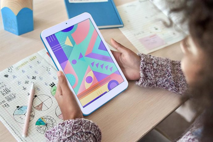 Archivo - Niña usando una tableta para estudiar