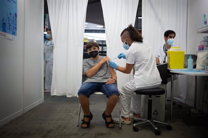 Un jove rep la primera dosi de la vacuna contra la Covid-19 en la primera jornada disponible per a la franja de 12 a 15 anys, en Fira Barcelona